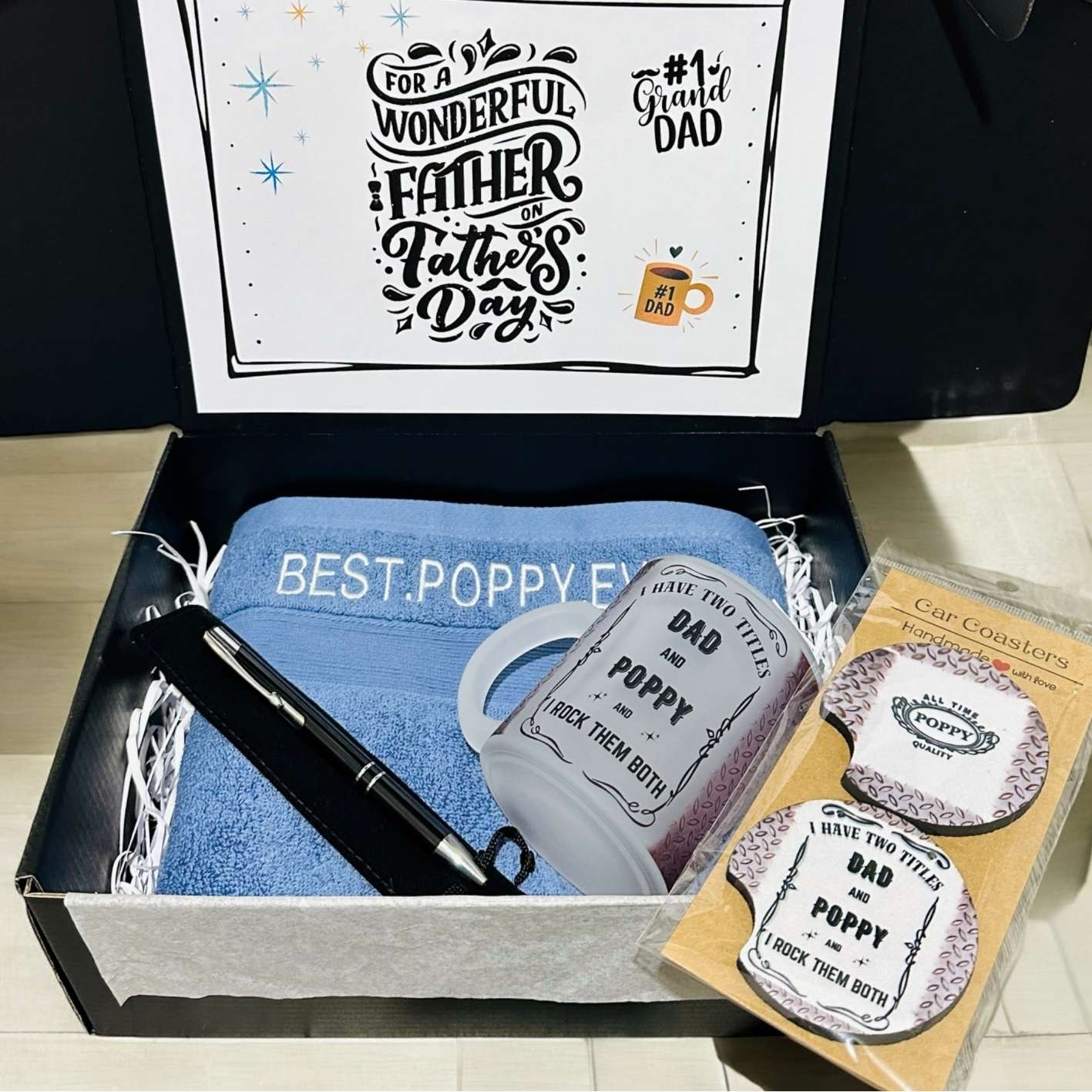 Gift set for Father's Day with towel, pen, coasters, and card in a box.