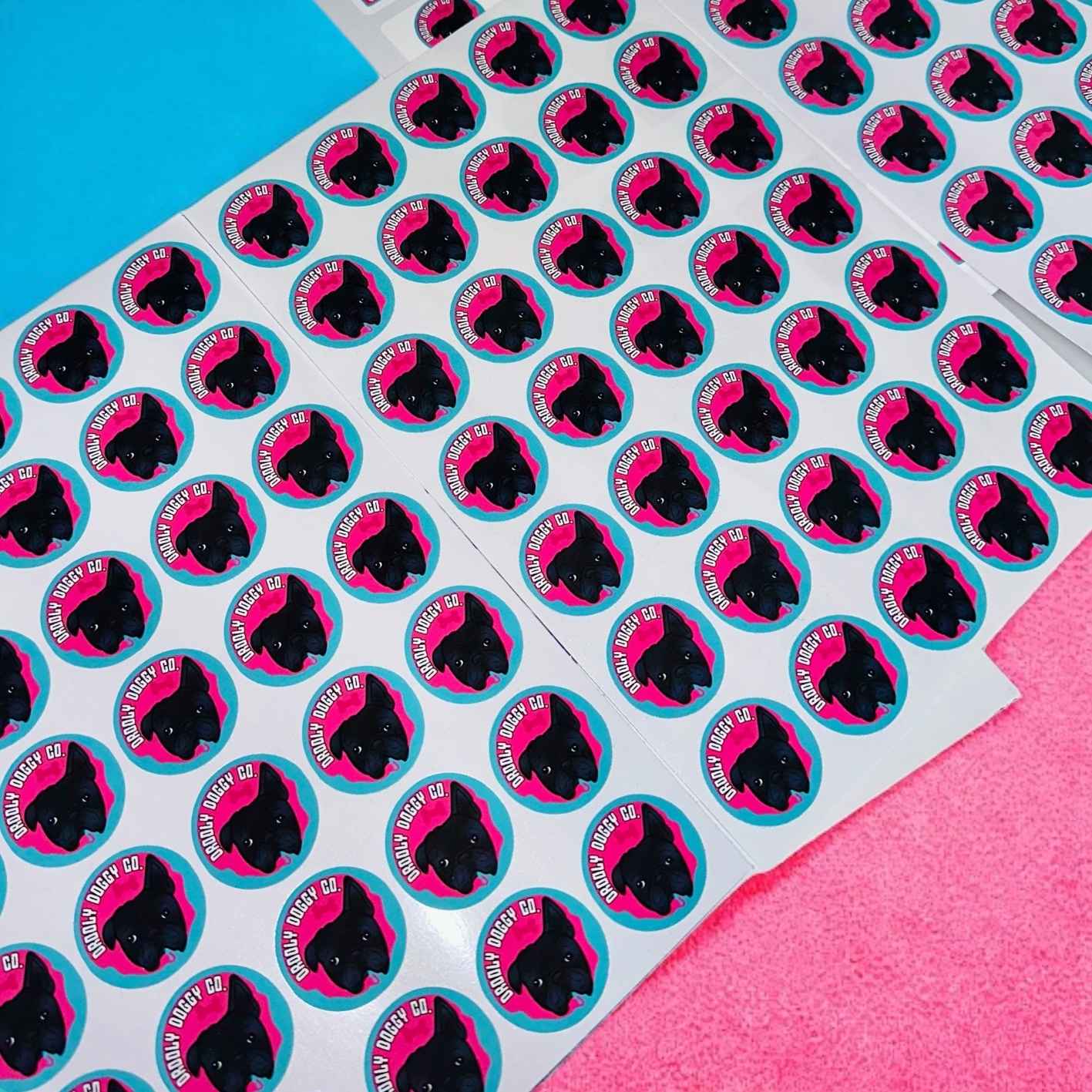 Stickers with customised business logo, pink and blue background.