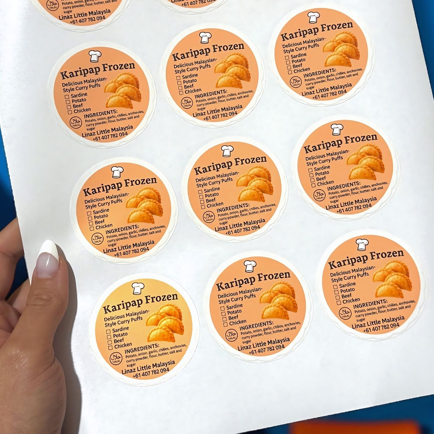 Sheet of orange custom printed business logo stickers in glossy finish.