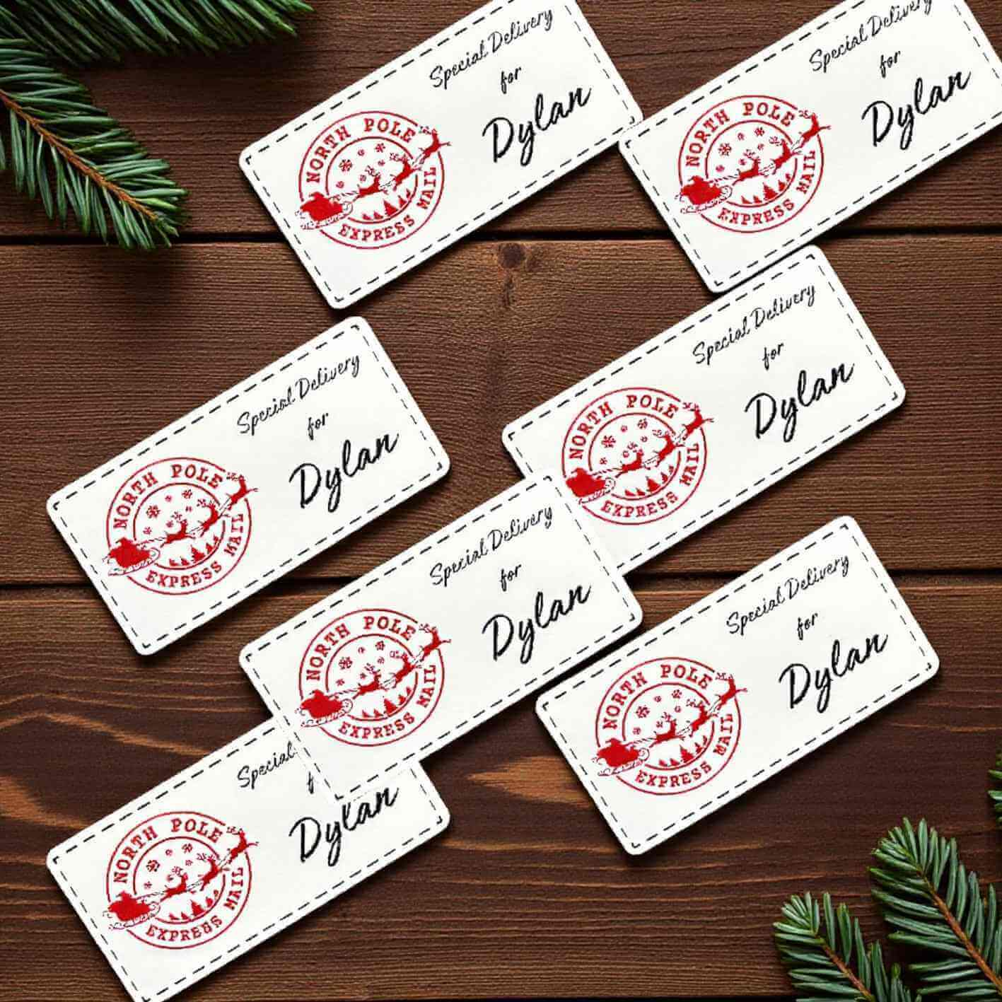 Set of personalized sticker labels with 'North Pole Express' stamp and name 'Dylan' on a wooden surface.