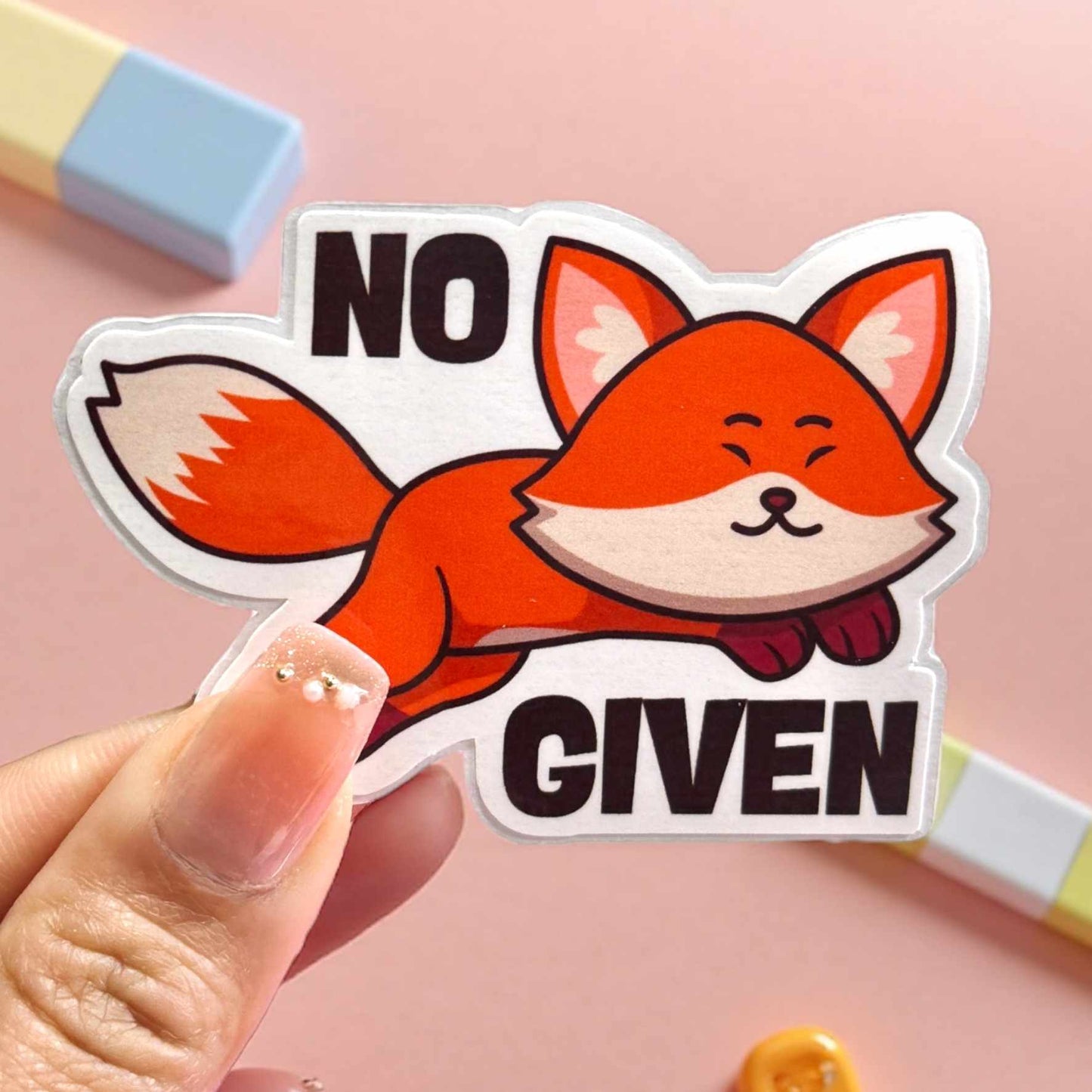 Sticker of a fox with 'No Given' text held by a hand on a pink background and cute stationery