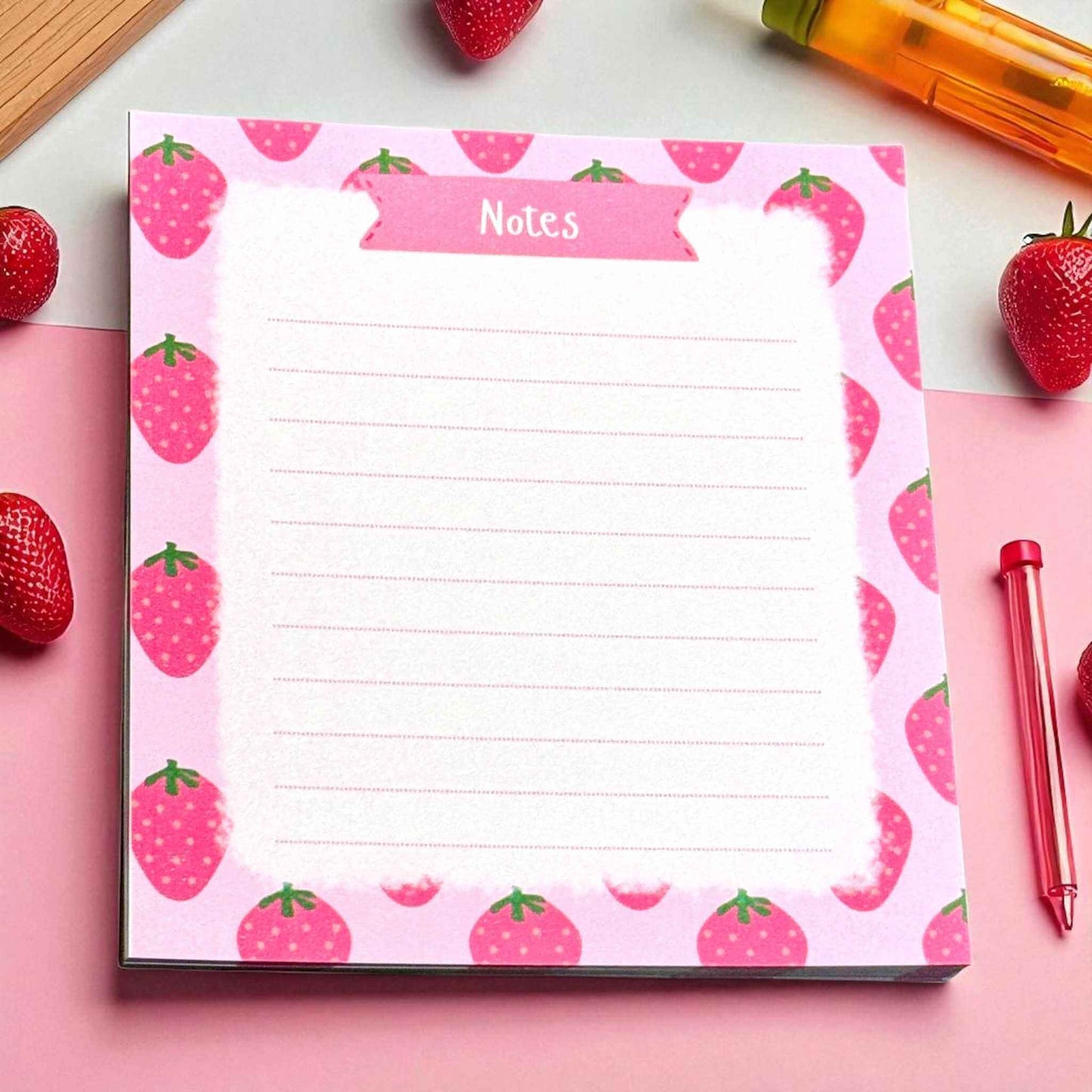 Handmade strawberry notes notepad featuring pink fruit pattern displayed with matching strawberries and writing tools - cute stationery accessories