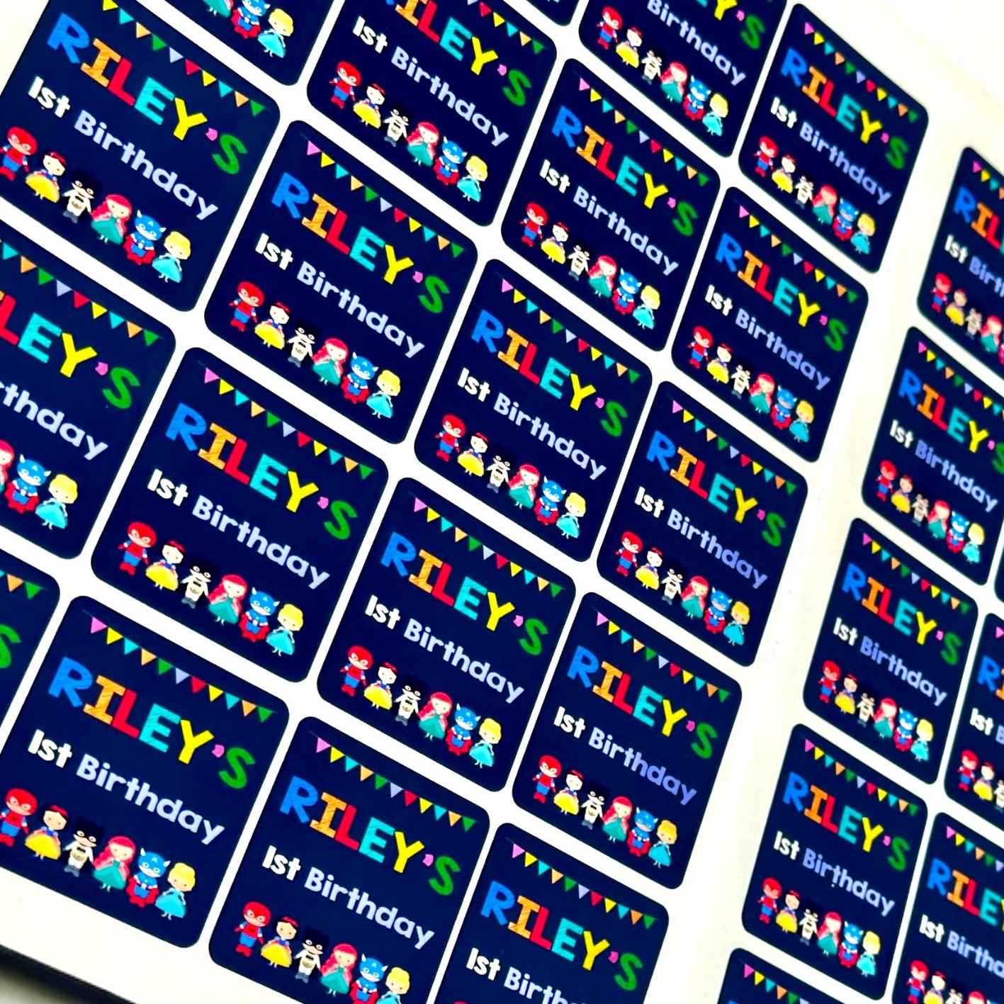 Personalized birthday stickers with 'Riley's 1st Birthday' text and colourful
Superhero themed custom prints.