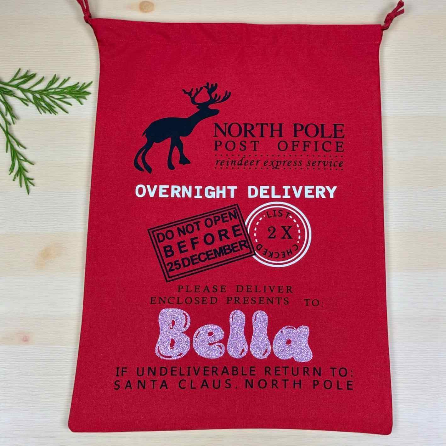 Red bag with Santa Claus-themed text and graphics on a light wooden surface.