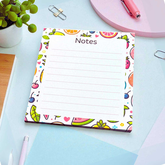 Handmade fruit design notes pad in stylish workspace setting with plant and pink office accessories - cute stationery shipped across Australia