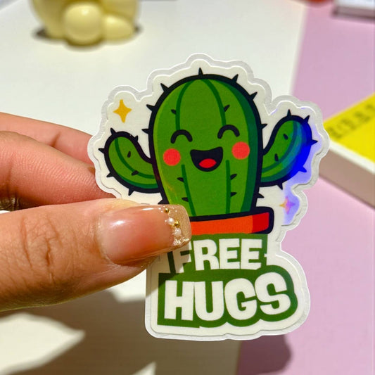 Sticker of a cactus with 'FREE HUGS' text held by a hand.