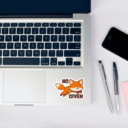 Laptop with a 'No Fox Given' sticker on a desk with pens and a phone.