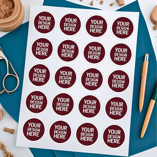 Sheet of round stickers with 'Your Design Here' text on a blue surface with stationery items.  