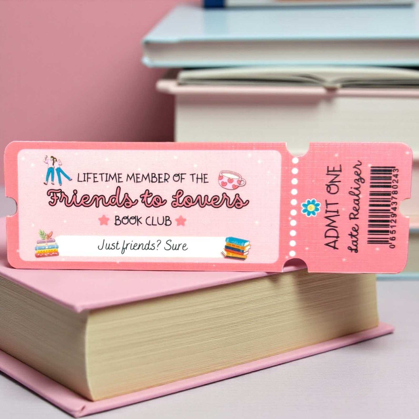 Pink book club bookmark membership ticket on a book with a pink background