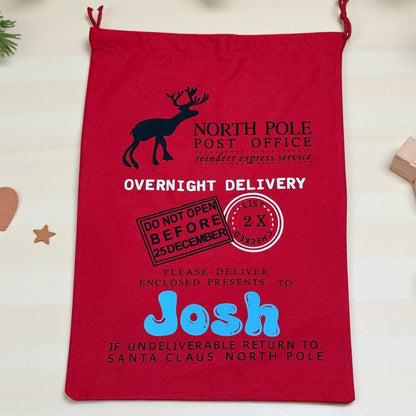 Large Red drawstring bag with Santa Claus-themed text and graphics on a light background