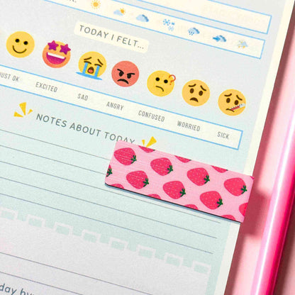 Custom strawberry-themed magnetic bookmark marking page in wellness journal with emoji mood tracker - book accessories shipped nationwide Australia Craftinspired